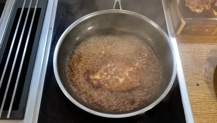 Hähnchenbrust in die Sauce geben und glasieren, bis sie schön lackiert ist.