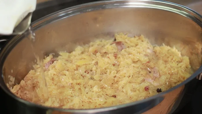 Alles mit heißem Wasser bedecken (Sauerkraut sollte bedeckt sein).