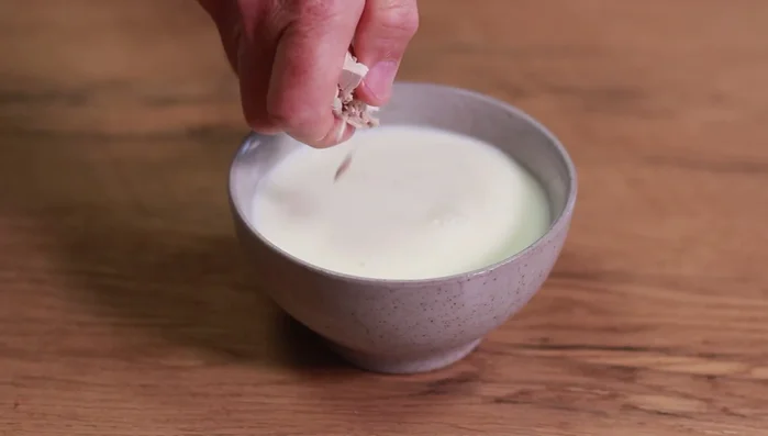 Für die Hefeklöße: Hefe in warmer Milch auflösen.