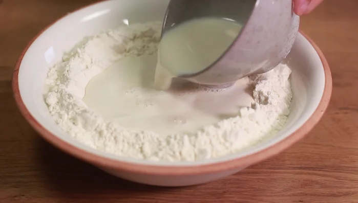 Mehl in eine Schüssel geben, Mulde formen und die Hefemilch hineingießen. Butter (in Stücke geschnitten), Salz hinzufügen und alles verkneten.