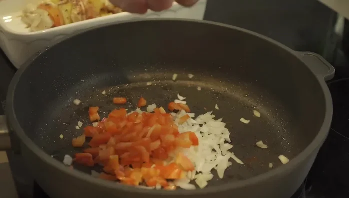 Übrige Paprika-, Zwiebel- und Ananasstücke in der Pfanne anbraten (274.5).