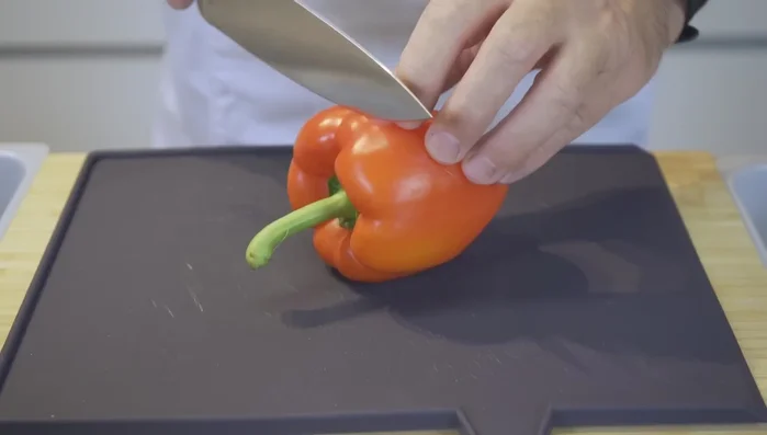 Paprika und Zwiebel putzen, Deckel und untere Ende entfernen. Paprika in gleichmäßige Stücke schneiden (22.02).