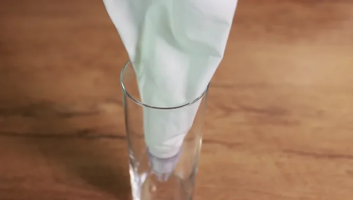 Kartoffelmasse mit einem Spritzbeutel auf den Hähnchenauflauf spritzen.