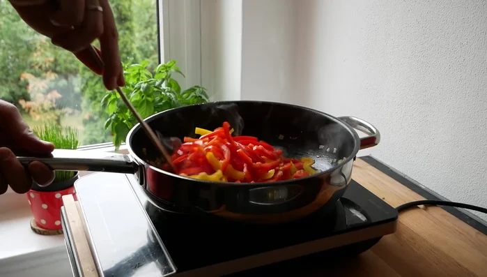Paprikastreifen hinzufügen und 4-5 Minuten mitbraten.