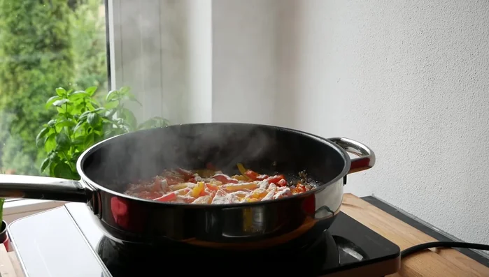 Mehl über die Paprika streuen, verrühren, mit Gemüsefond und Sahne ablöschen.