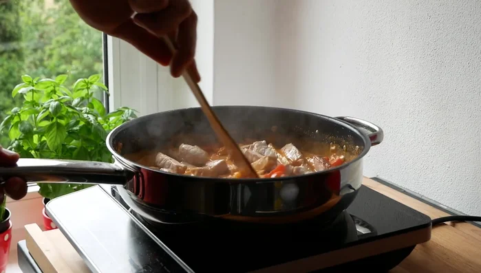 Hitze ausschalten, Fleisch zurück in die Pfanne geben und 2 Minuten ziehen lassen.