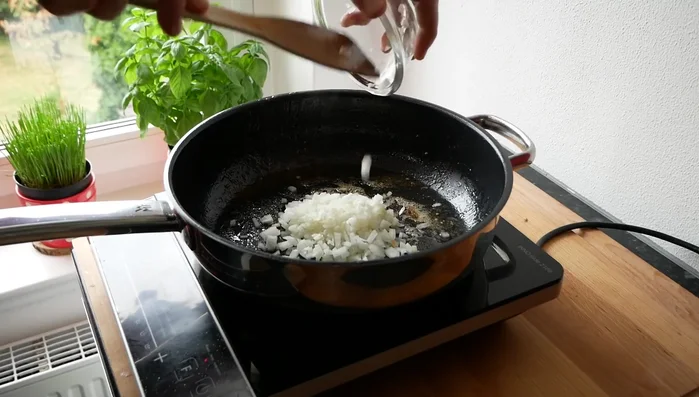 Hitze reduzieren, Zwiebeln und Knoblauch glasig anschwitzen (1-2 Minuten).