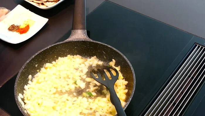 Mariniertes Hähnchenfleisch hinzufügen und anbraten (erste 2 Minuten auf höchster Stufe, danach auf Stufe 6-5).