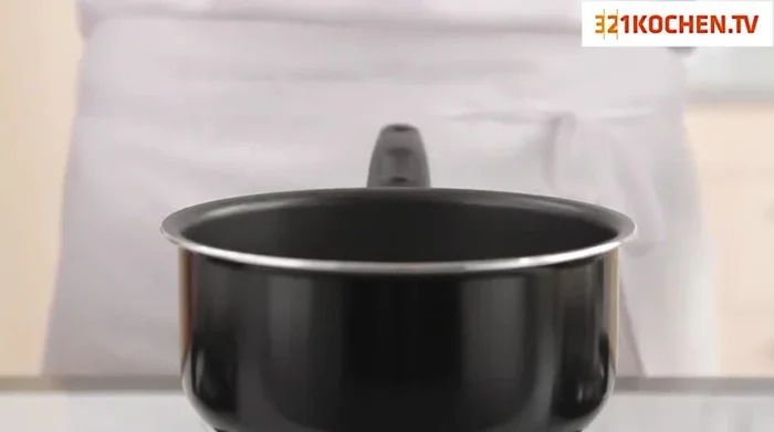 Milch, Kakaopulver, ein Stück Orangenschale und etwas Zucker in einen Topf geben und aufkochen lassen.
