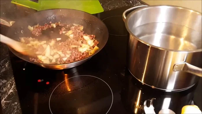 Für die Soße: Speck, Zwiebel und Knoblauch anbraten, Paprika, Tomaten hinzufügen und köcheln lassen.