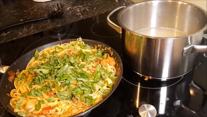 Basilikum und Parmesan über die Pasta geben. Medaillons aus dem Ofen nehmen (Kerntemperatur ca. 63°C) und auf der Pasta anrichten.