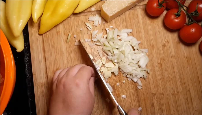 Zwiebel und 1 Knoblauchzehe fein würfeln, in der Pfanne anbraten.