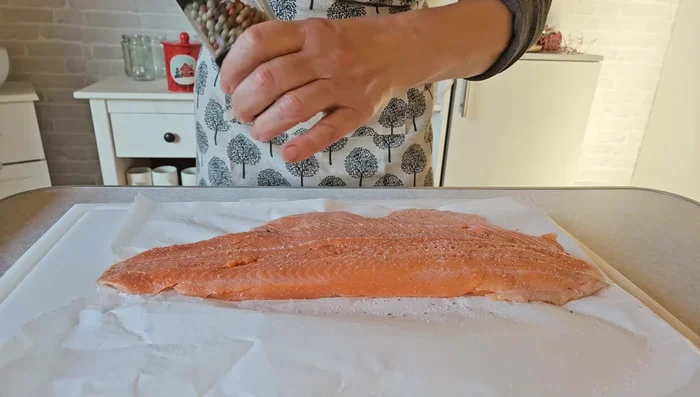 Lachsforelle von oben salzen und pfeffern. Schmales Endstück abschneiden und obenauf legen.