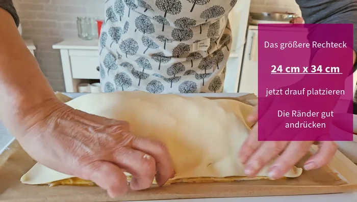 Größeres Blätterteigrechteck (24x34cm) darüberlegen und die Enden fest andrücken. Enden nach oben klappen und kordelartig eindrehen.