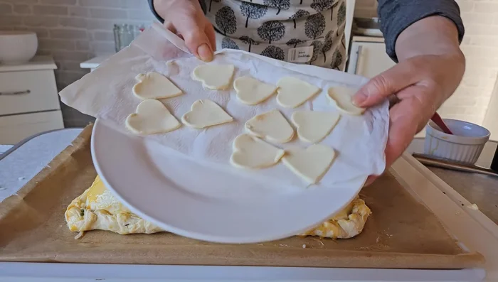 Mit Eigelb bestreichen. Blätterteigreste optional mit Ausstecher formen und ebenfalls mit Eigelb bestreichen und obenauf legen.