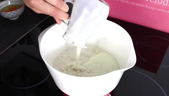 Buttermilch und Eier hinzufügen und mit einem Handrührgerät einige Minuten verrühren, bis ein glatter Teig entsteht.