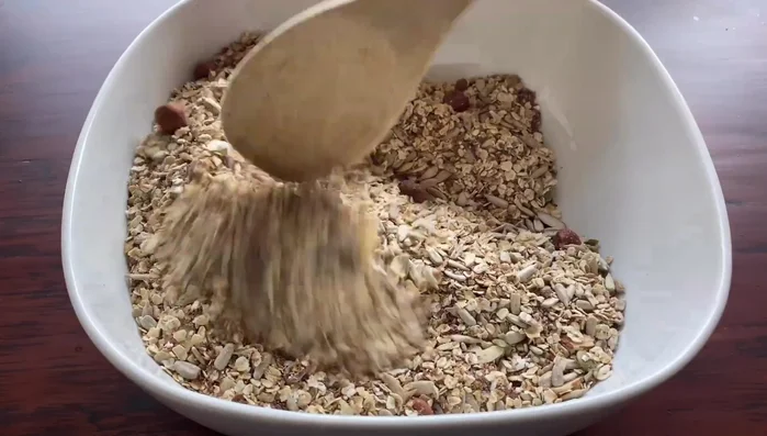 Die Wassermischung zu den trockenen Zutaten geben und alles gründlich vermengen, bis ein gleichmäßiger Teig entsteht.