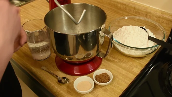 Brotstarter, Wasser, Hefe und braunen Zucker in die Schüssel des Mixers geben. Auf niedriger Stufe vermischen, bis alles gut vermischt ist. (169.799)