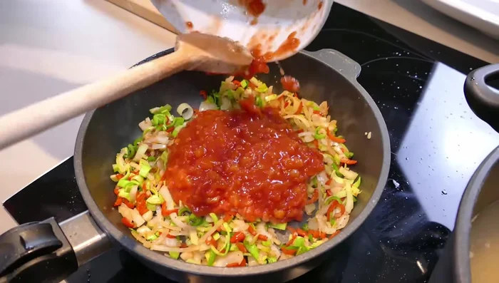 Stückige Tomaten hinzufügen und kurz aufkochen (240.11). Eine Prise Zucker hinzufügen (248.66).