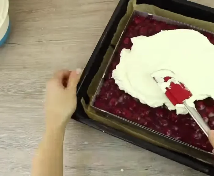 Restliche Sahne auf die Kirschmasse streichen und mit Schokoraspeln bestreuen.