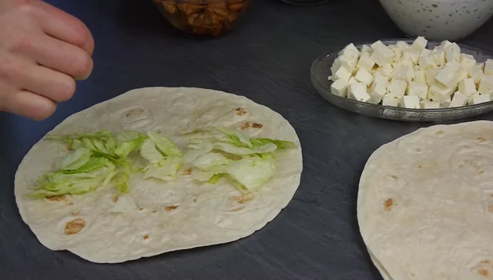 Tortillas mit Hähnchenbrust, Gemüse und Feta-Käse belegen (nicht zu viel Füllung verwenden!).