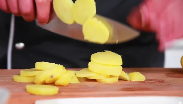 Kartoffeln schälen und in Scheiben schneiden.