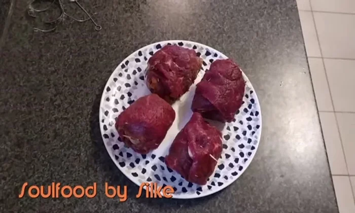 Rouladen mit Rotwein und Rinderbrühe in den Schnellkochtopf geben. Fast vollständig bedecken.