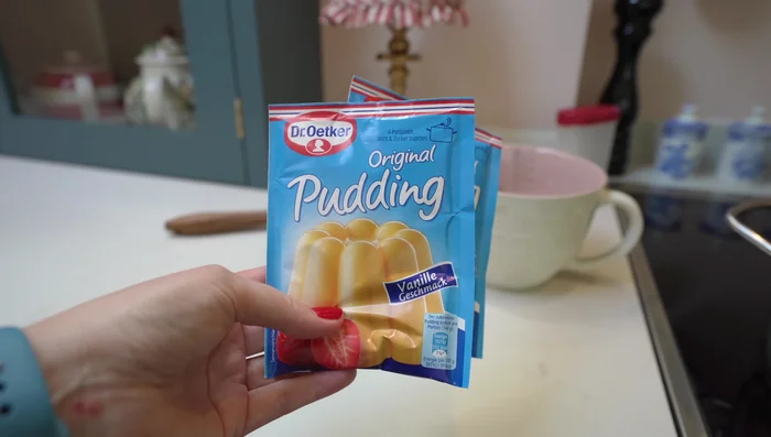 Vanillepudding zubereiten und abkühlen lassen (mit Frischhaltefolie abdecken).