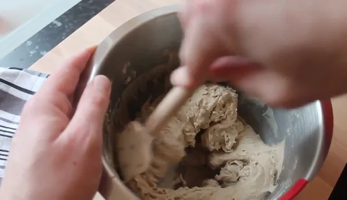 Teig mit einem Teigschaber von der Schüssel lösen und zu einer Kugel formen. An einem warmen Ort 1 Stunde gehen lassen.