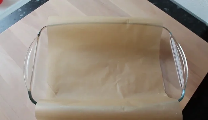 Auflaufform mit Backpapier auskleiden.