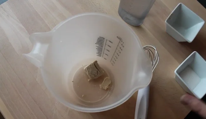 Hefe, Zucker und lauwarmes Wasser verrühren, bis sich der Zucker und die Hefe aufgelöst haben.