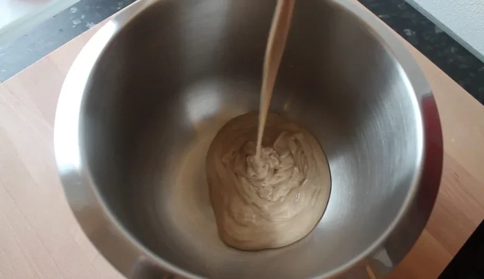 Roggensauerteig, Roggenmehl, Weizenmehl und das Hefe-Wasser-Gemisch in einer Rührschüssel vermischen.