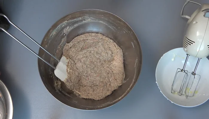 Teig in eine mit Backpapier ausgelegte Backform geben, glatt streichen und mit Sonnenblumenkernen bestreuen.