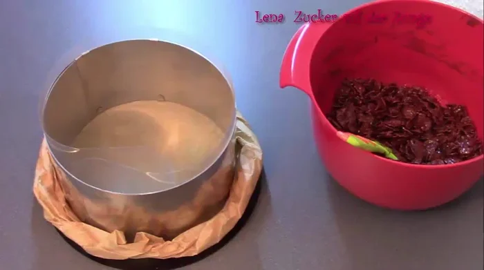 Die Masse in einen 18cm Tortenring (mit Backpapier und Tortenrandfolie ausgelegt) drücken und für mindestens 30 Minuten kühl stellen. (136.739)