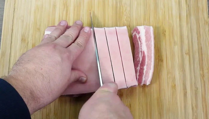 Schweinebauch in 1,5 cm dicke Scheiben schneiden. (Für bessere Verarbeitung 3 Stunden vorher ins Gefrierfach legen). Schwarte entfernen (optional).