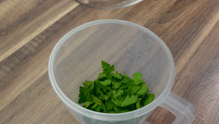 Zutaten für die Kräutermarinade (Petersilie, Rosmarin, Oregano, Pfeffer, Paprikapulver, Salz, Knoblauch, Zwiebel, Ketchup, Senf, Sahne) in einen Messbecher geben und mit einem Pürierstab vermischen.