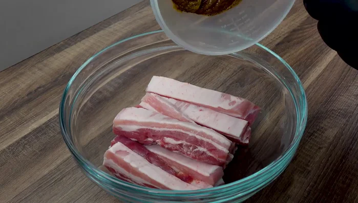 Bauchscheiben in eine Schale geben und mit der Marinade vermengen. 30 Minuten marinieren lassen.