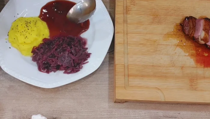Entenbrust mit Rotkohl, Kartoffel-Kürbispüree, Soße und Apfelsternen anrichten.