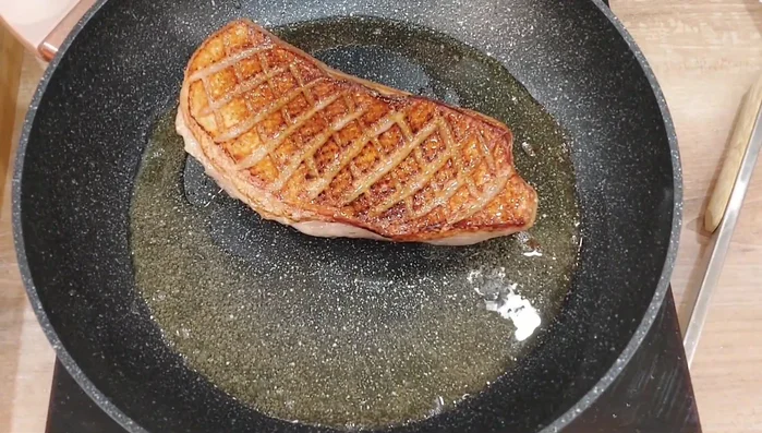 Knoblauch (halbiert) und Thymian zum Entenfett geben.