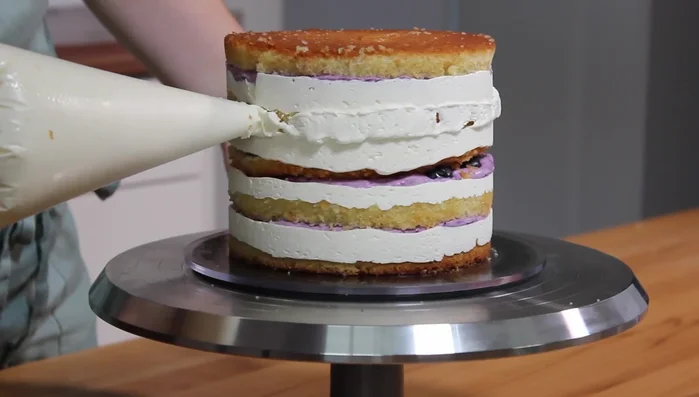 Buttercreme auf die Torte streichen.