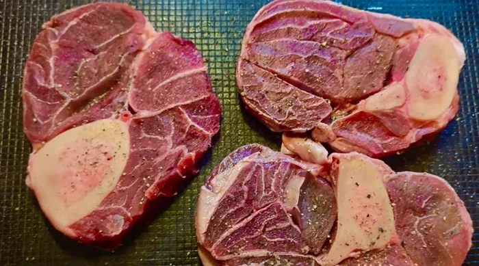 Beinscheiben am Rand leicht einschneiden, würzen und melieren.