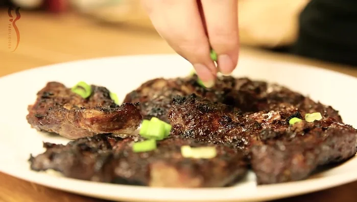 Mit Lauchzwiebeln und Limettenspalten garnieren und servieren.